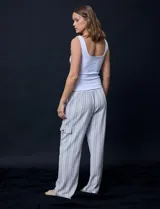 Pantalón cargo de lino color blanco, marca Marissa Olivia. Tiene pretina ancha elastizada con lazo de ajuste, bolsillos inclinados delanteros y bolsillos laterales con botón.