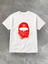 Remera blanca de algodón con estampa roja de una persona con pasamontañas.