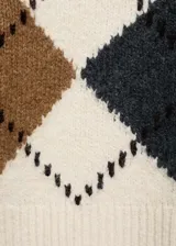 Sweater de punto color crema con diseño de rombos en marrón, gris y ocre. Tiene cuello en V y mangas largas con terminaciones en canalé.