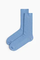 Medias de vestir celestes con textura acanalada y borde superior elástico.