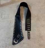 Cinto faja de cuero sintético negro con hebilla metálica plateada y apliques de tachas plateadas.
