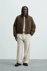 Pantalón de vestir color beige, corte wide fit, con cintura elástica, pliegues frontales, bolsillos laterales y traseros de vivo.