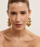 Aros dorados tipo argolla con esferas colgantes.