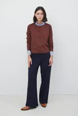 Remera de manga larga con diseño de rayas horizontales en azul y blanco, destacada por un cuello redondo en color bordó con costuras a la vista.