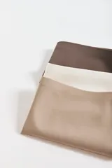 Pack de tres colaless de corte láser en colores marrón, blanco y beige.