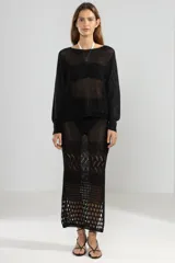 Sweater negro de tejido calado con lurex, escote barco y manga larga. Tiene un tigre insignia de Polonio en la espalda.