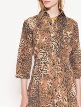 Vestido corto de gabardina con estampado animal print, corte entallado en la parte superior y falda tableada.