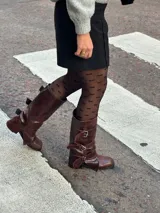 Borcegos de cuero color chocolate con efecto gastado. Caña alta con tres correas con hebillas plateadas. Taco bajo. Industria Argentina.