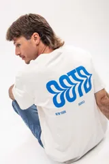 Remera oversize color blanco con estampado de ciudades en el frente.