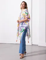 Kimono tejido con estampado abstracto en tonos azul, amarillo y blanco. Tiene mangas amplias estilo japonés y terminación de ruedo con borlas.