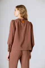 Chaqueta negra de lino con mangas abullonadas y cierre frontal con botones.