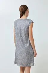 Vestido corto plateado con lentejuelas, escote en V y mangas cortas.