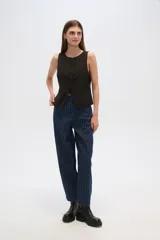 Pantalón jean negro con finas rayas verticales blancas, de corte amplio y tiro alto.
