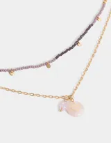 Collar corto multicadena con mostacillas lilas y dije de corazón místico dorado.