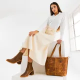 Botas cortas de cuero color marrón, con taco de madera forrado en cuero, elástico lateral y punta fina.