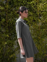 Vestido camisero verde seco de corte holgado, con cuello camisero, mangas 3/4 y cierre frontal con botones.