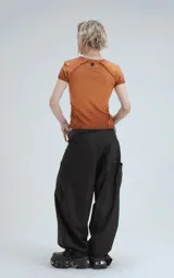 Remera de manga corta y cuello redondo, confeccionada en tejido ribb 100% algodón, de calce ajustado al cuerpo y largo a la cadera. El color es un marrón oscuro con efecto desgastado o teñido. Presenta costuras externas visibles en los hombros y laterales.