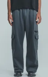 Pantalón de jogging de frisa color gris melange oscuro, con cintura y puños elásticos. Posee dos bolsillos laterales, un bolsillo trasero y un bolsillo lateral adicional con cierre.