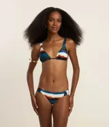 Traje de baño de dos piezas con estampado de rayas acuareladas. El top es triangular con breteles anchos fijos, lazo en la espalda y copas removibles. La bombacha es de corte clásico.