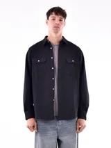 Camisa negra de manga larga con dos bolsillos frontales con botón.