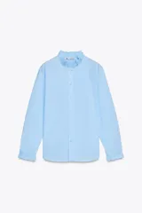 Camisa celeste de algodón con cuello con volantes y mangas largas con puños fruncidos.
