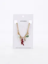 Collar dorado con cadena de eslabones y dijes colgantes con motivos marinos: conchas, estrellas de mar, abanicos y una rama de coral roja.