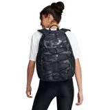 Mochila Under Armour negra con logo blanco, tecnología UA Storm resistente al agua, panel trasero acolchado, correas ergonómicas ajustables, funda para laptop de hasta 15 pulgadas, cordón frontal elástico y dos bolsillos laterales para botellas.
