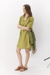 Vestido corto verde de lino, con cuello en V y mangas cortas.