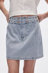 Minifalda de jean negra con detalle de ojales metálicos en la cintura.