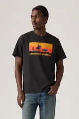 Remera negra de corte relajado con estampado rectangular en el pecho que muestra un paisaje del oeste americano con un jinete a caballo y la leyenda "Levi Strauss Overalls".