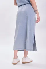 Falda midi celeste con efecto lavado, cintura elastizada con cordón ajustable y tajo lateral.