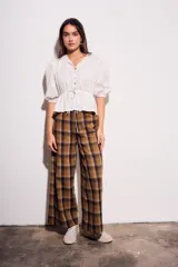 Pantalón de tiro medio, corte recto y pierna ancha, con estampado de cuadros escoceses en tonos marrón, beige y negro.