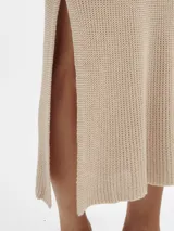 Vestido largo tejido en jersey color beige, con escote bote y corte con abertura en los laterales.