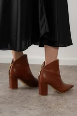 Botas de cuero color borgoña con punta fina y taco cuadrado. Cierre con cremallera dorada en la parte posterior.