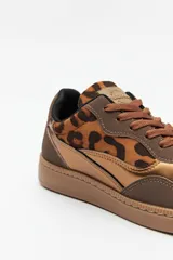 Zapatillas bajas de cuero sintético color marrón con estampado animal print y detalles metalizados.