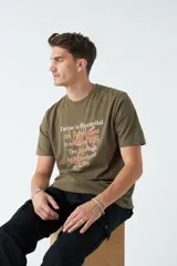 Remera verde militar de corte clásico con estampado frontal de texto en color ladrillo y dibujo de hojas.