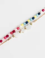 Set de dos pulseras doradas con cuentas de colores y dijes de nácar en forma de corazón y estrella.