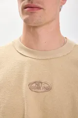 Remera color tostado de manga corta con estampa en el frente.