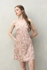 Camisón corto de silueta femenina y liviana, con estampado de hojas en tonos beige y negro. Presenta escote en V con detalle de encaje delicado, breteles finos y regulables, y corte evasé.