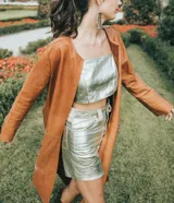 Tapado marrón de cuero con corte a la rodilla, mangas largas y aberturas laterales.