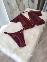Conjunto de lencería color bordó, compuesto por un top de lycra, microtul y encaje elastizado con broche de gancho y espalda de microtul con detalles de encaje, y una tanga regulable de los mismos materiales con forro de algodón.