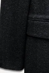 Abrigo largo de Zara Woman Collection confeccionado en tejido con 30% lana. Tiene cuello solapa de muescas, manga larga con abertura y botones, bolsillos con solapa en el delantero y de vivo en el pecho. Forro interior a tono y cierre frontal cruzado con botones.