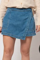 Short pollera de jean de tiro alto, color celeste, con cierre trasero invisible y detalle de bolsillos delanteros.