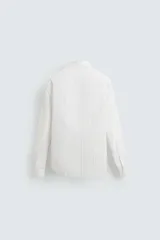 Camisa blanca con estampado de cuadros en tonos grises y amarillos, de corte regular fit, cuello italiano, manga larga con puños abotonados y cierre frontal con botones.