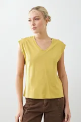 Remera verde pistacho de corte recto, con cuello en V y botones decorativos en los hombros.