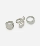 Set de tres anillos plateados de metal reciclado con diferentes diseños: uno con forma de gota doble, otro con eslabones dobles y un tercero con forma de gota arrugada.