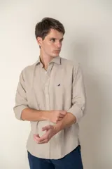 Camisa celeste de lino con cuello clásico y manga larga. Presenta un pequeño logo bordado en el pecho.