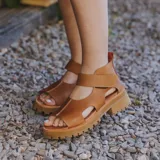 Sandalias de cuero color marrón claro, con puntera descubierta, tira ancha sobre el empeine, talonera cerrada y suela track.