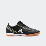 Championes indoor Le Coq Sportif modelo Magic Match, color negro con detalles en amarillo flúor. Presentan el logo del gallo en blanco y la inscripción "le coq sportif" en el talón. La suela es de goma color caramelo.