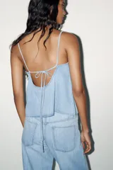 Top celeste de denim con escote en pico y tirantes finos regulables.